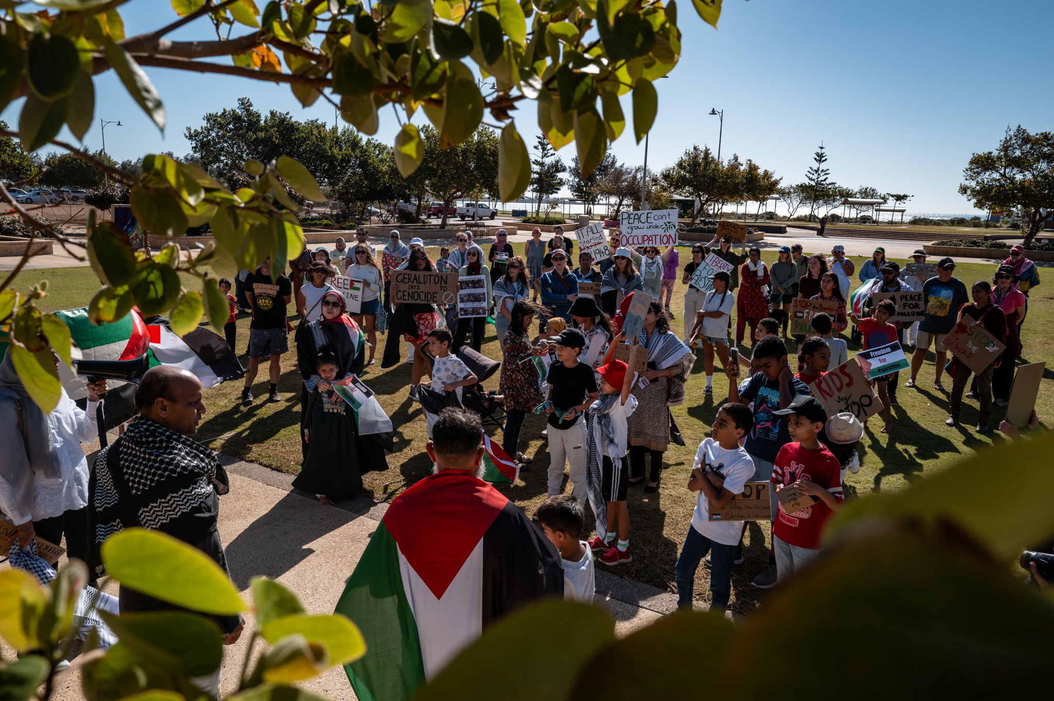 Crowd of approximately 50 people gathering at Edith Cowan Gardens for the solidarity march