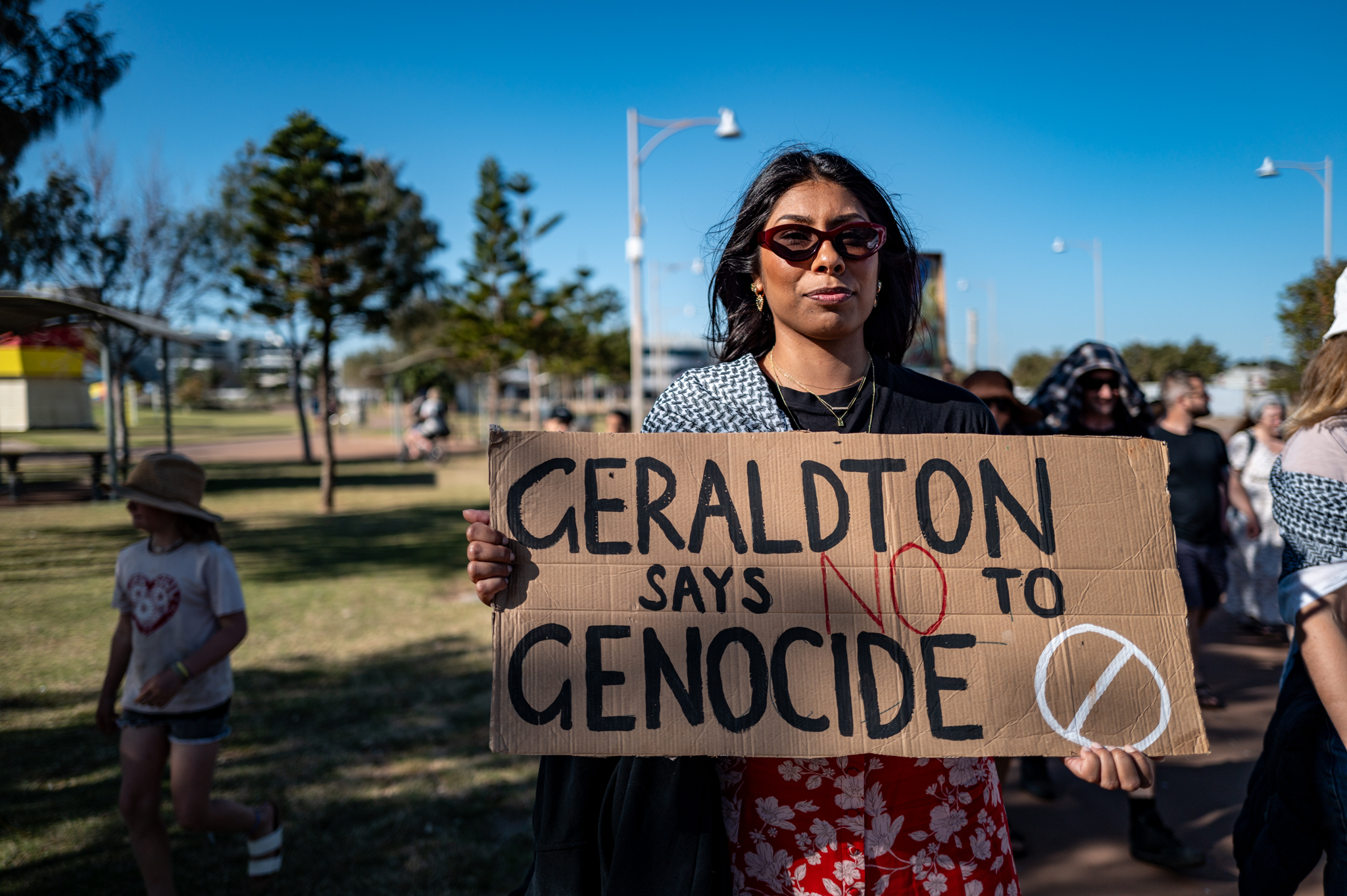 A young person carries a poster in support of Palestine